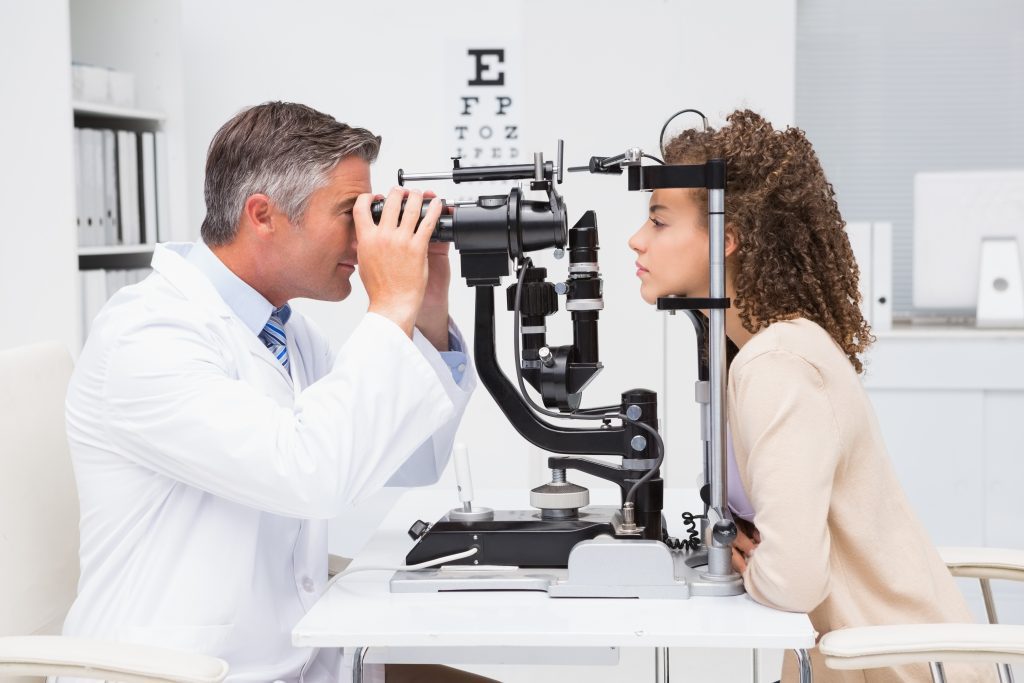 A young woman gets her eyes tested with a doctor.