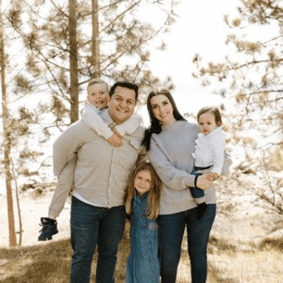 Allyson with her family posing in a forest